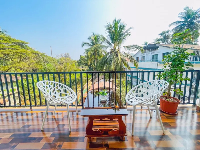 Balcony with two chairs looking over coconut palms