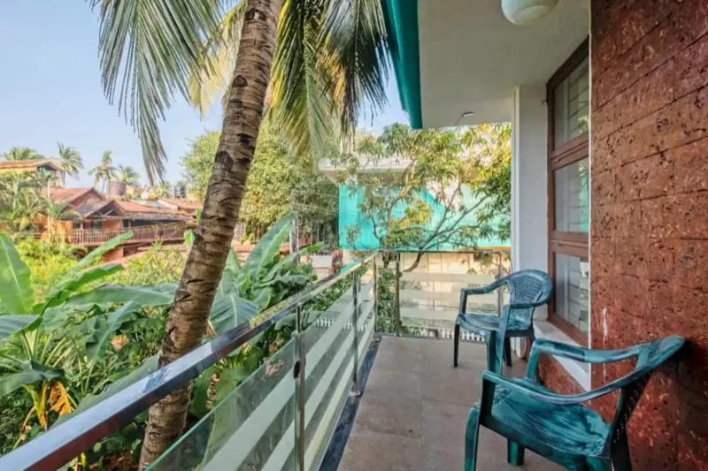 Balcony with chairs among coconut palms