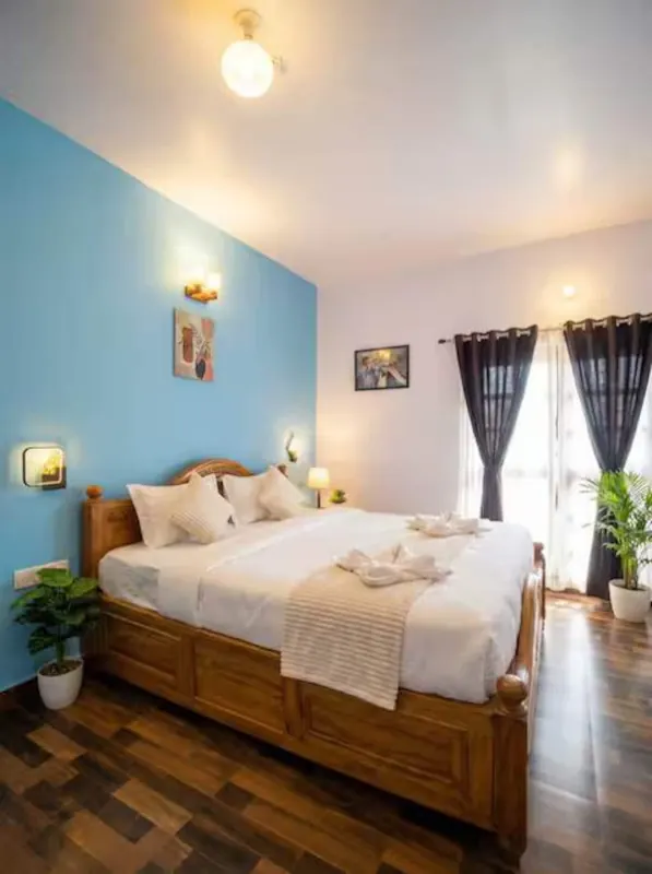 King bedroom with a blue feature wall and balcony door