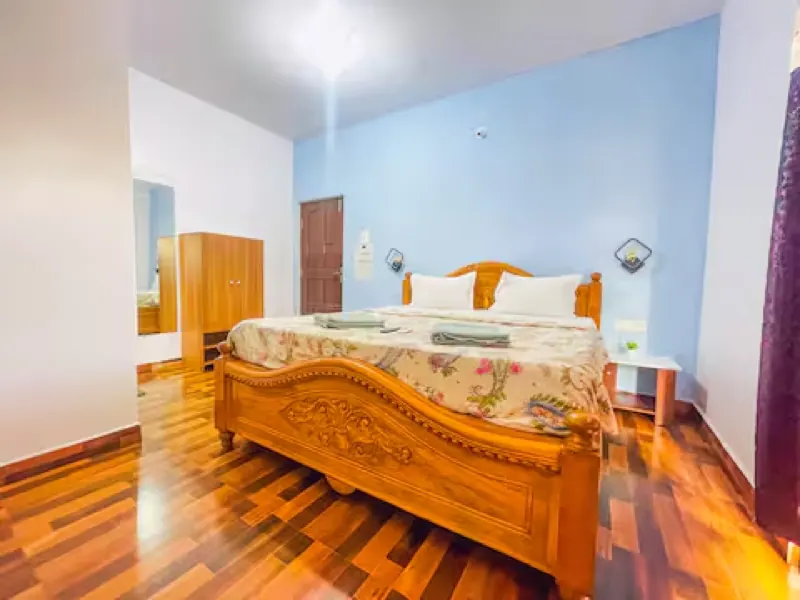 Bright ensuite bedroom with a carved wooden king bed