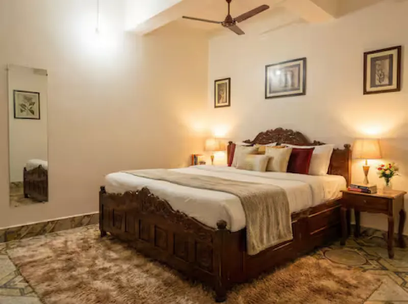 Warm-lit king bedroom with a carved headboard