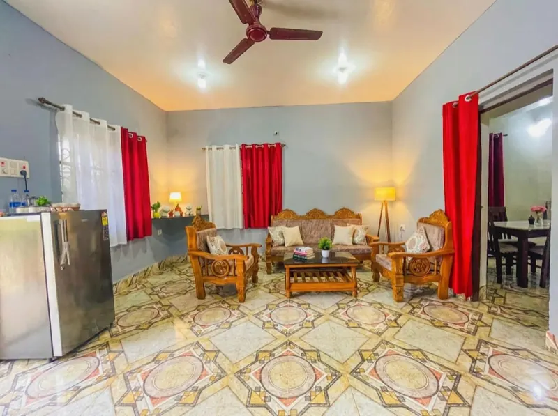 Living room with carved wooden sofas and dining corner