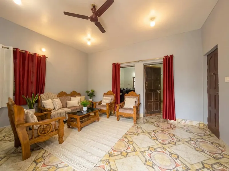Living room with red curtains and wooden sofas
