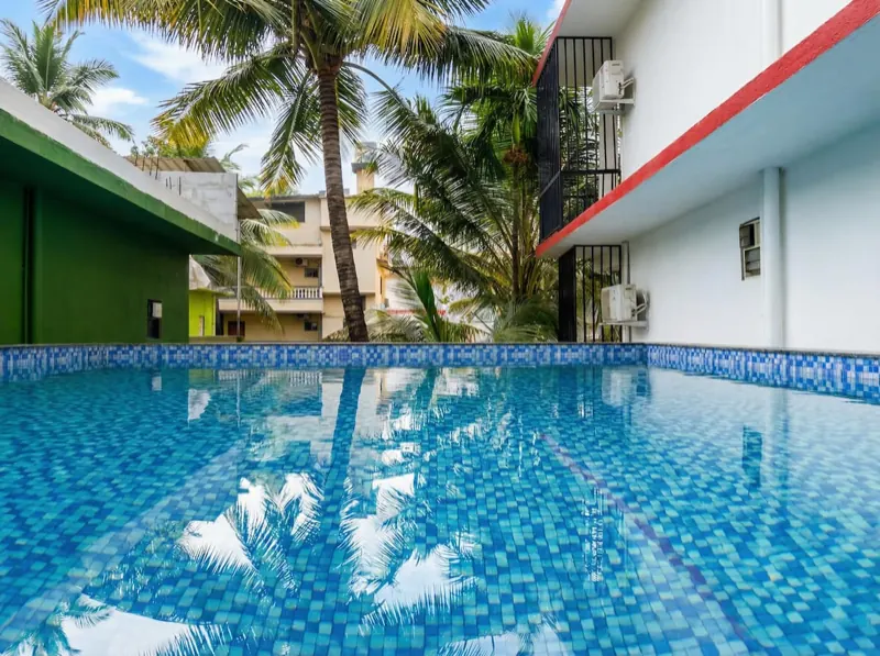 Pool with palm tree reflections at Celeste Stay, Calangute